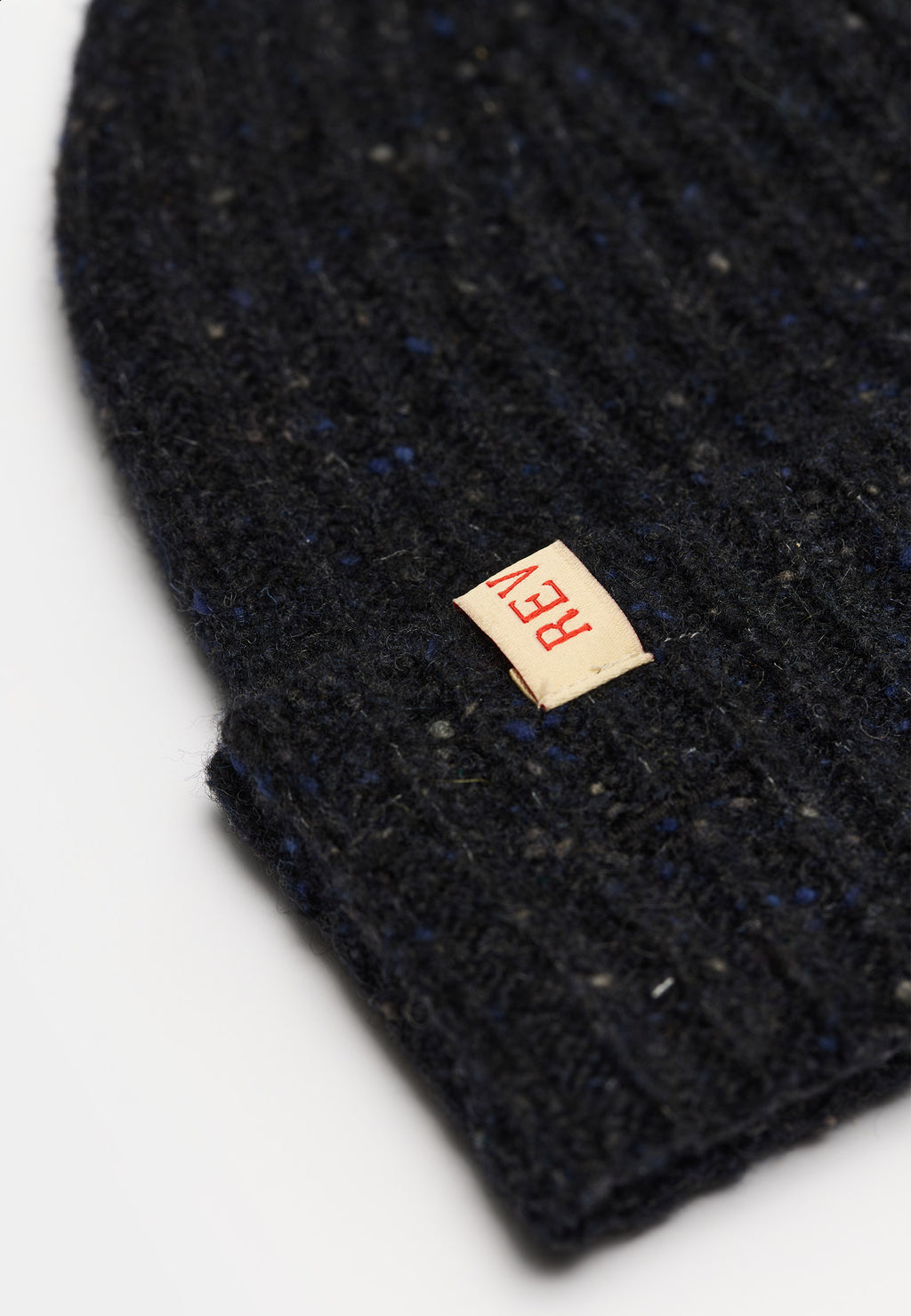 Nærbillede af rib-strik og læderlabel på Revolution Melange beanie 9317 i mørk navy