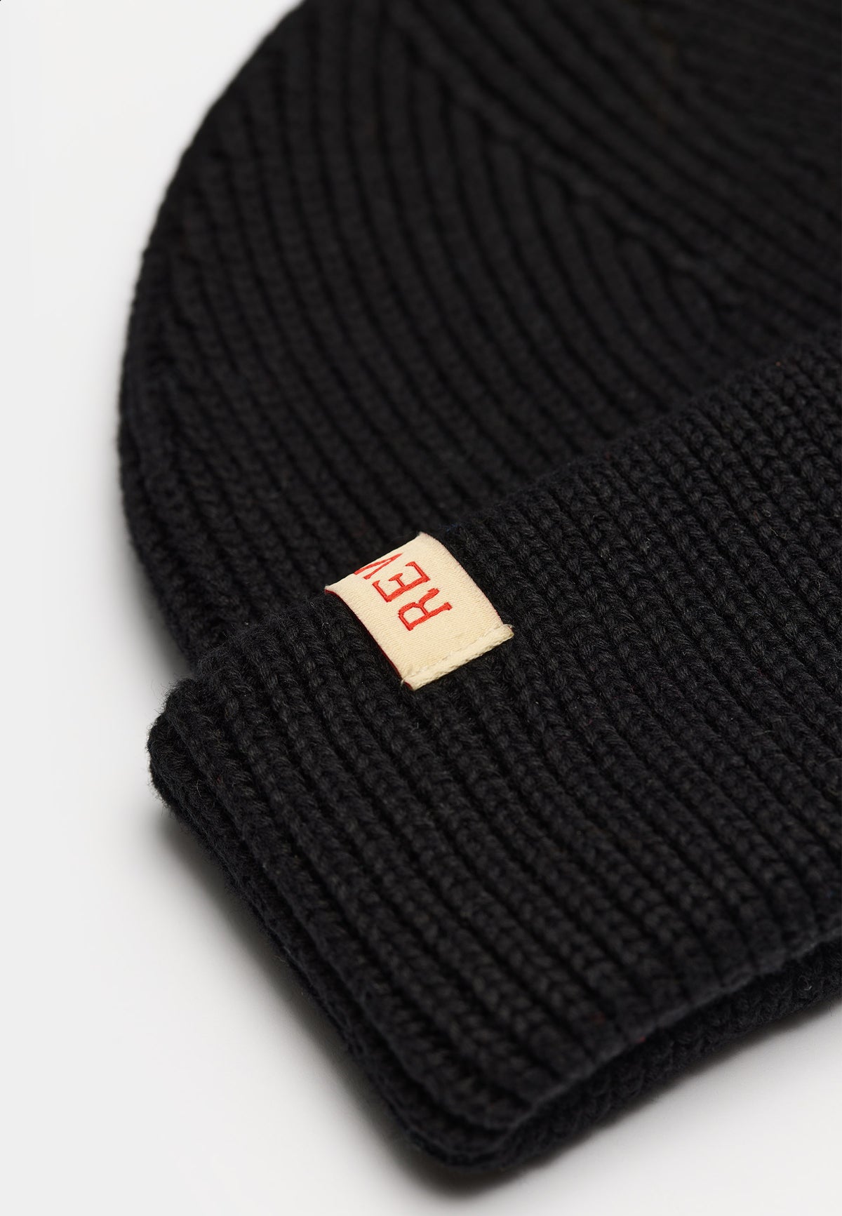 Nærbillede af rib-strik og læderlabel på Revolution Fisherman beanie 9324 i sort
