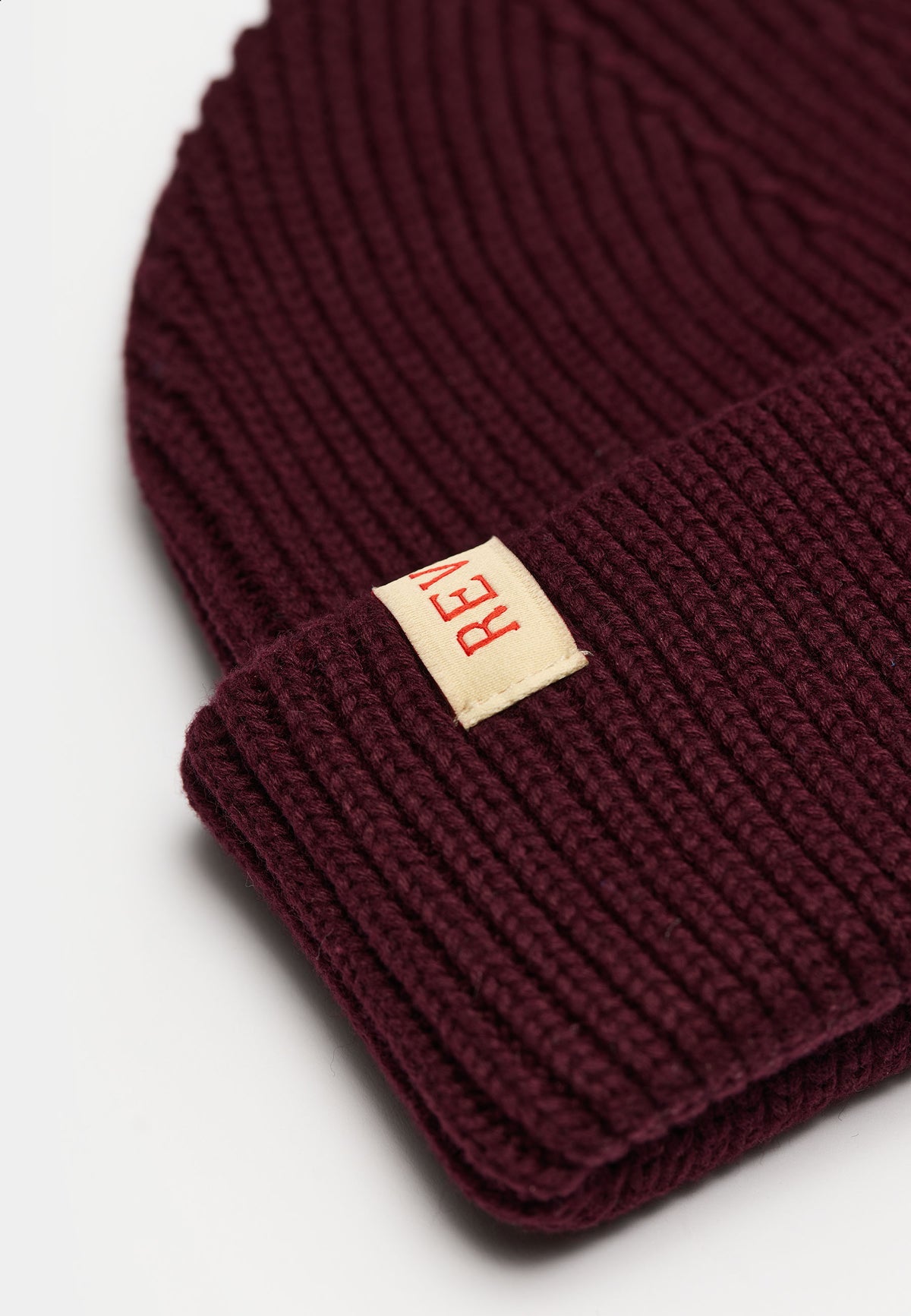 Nærbillede af rib-strik og læderlabel på Revolution Fisherman beanie 9324 i bordeaux