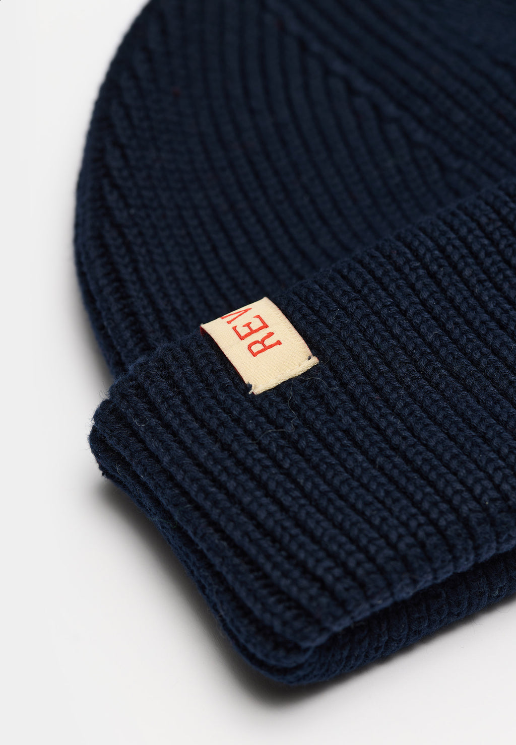 Nærbillede af rib-strik og læderlabel på Revolution Fisherman beanie 9324 i navy