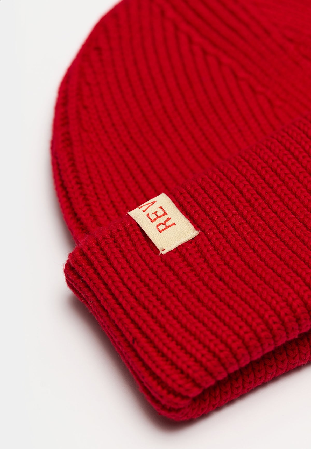 Nærbillede af rib-strik og læderlabel på Revolution Fisherman beanie 9324 i rød