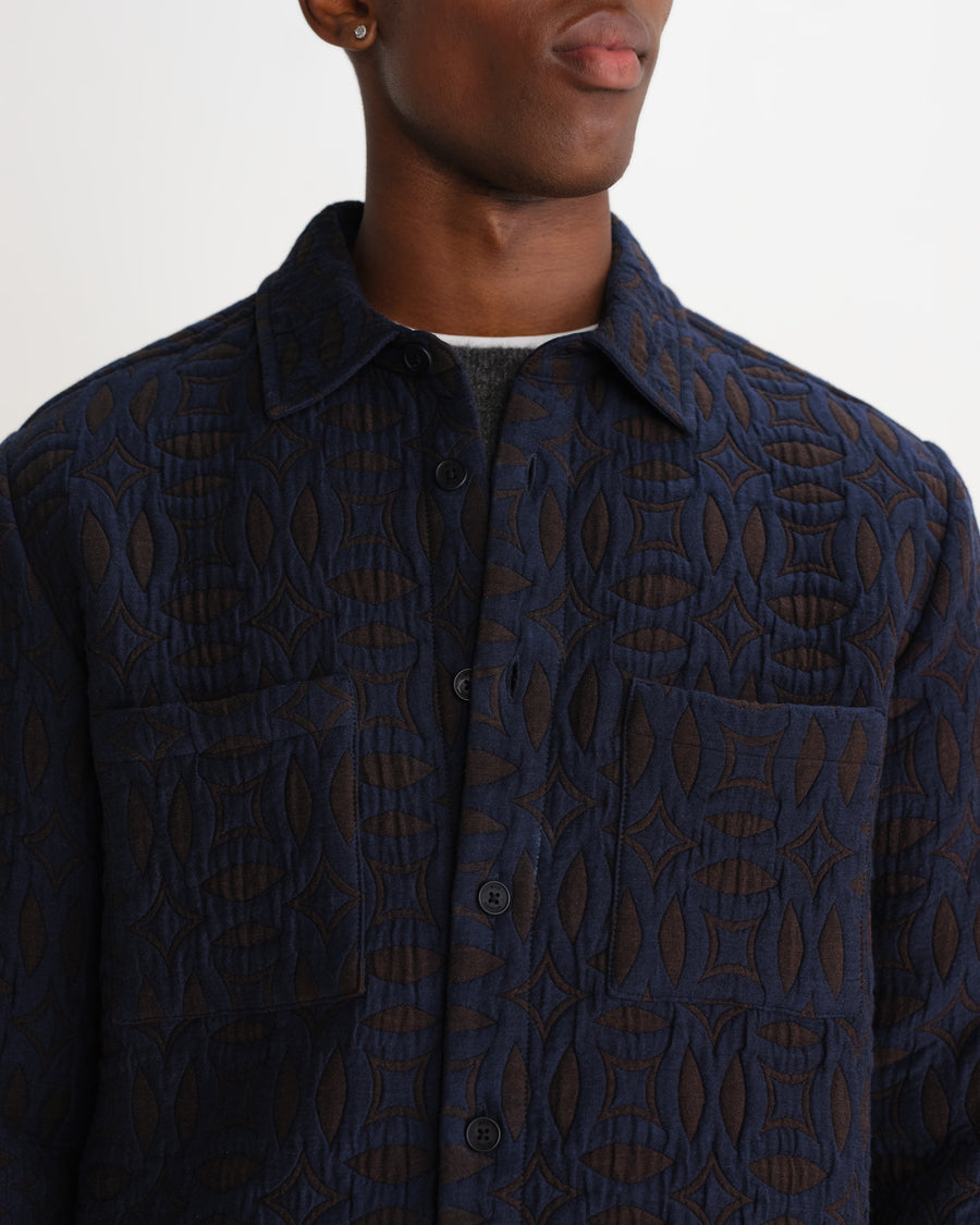 Nærbillede af quiltet stof på Wax London Otto quiltet overshirt i navy og brun