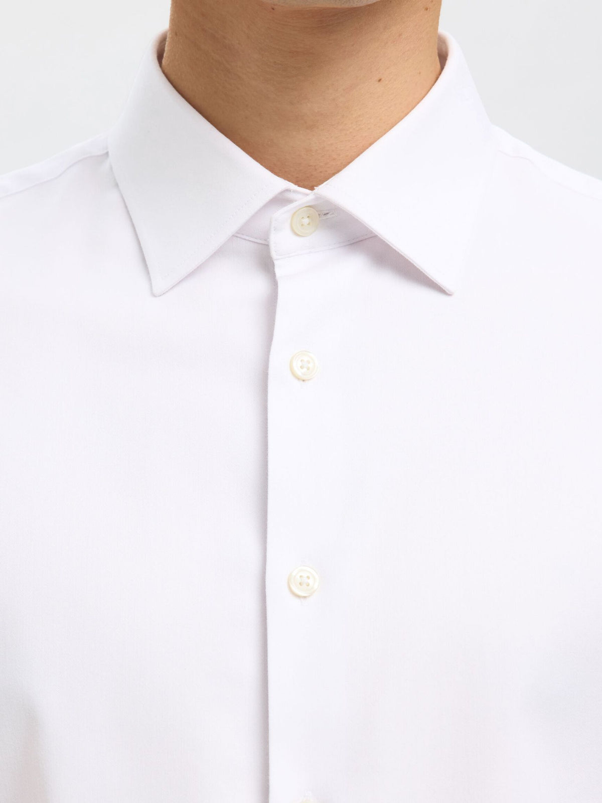 Nærbillede af krave og knapper på Selected Performance Stretch Slim Fit skjorte i hvid