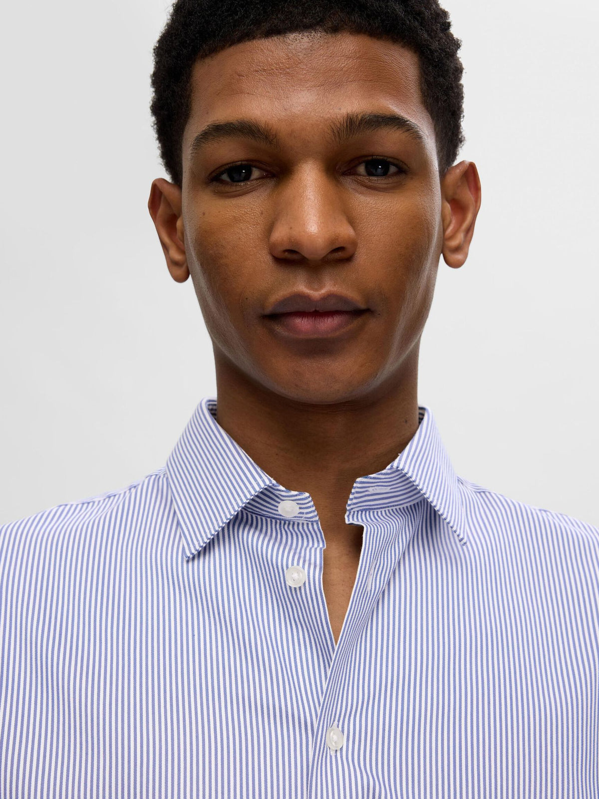 Nærbillede af model i Selected Performance Stretch Slim Fit skjorte i lyseblå med True Navy striber
