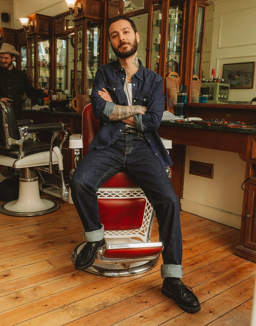 Model i LEE Regular Western denimskjorte i Rinse mørkeblå i barberstol – stemningsbillede