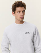 Nærbillede af brystlogo på Les Deux Signature print sweatshirt i Snow Melange lysegrå