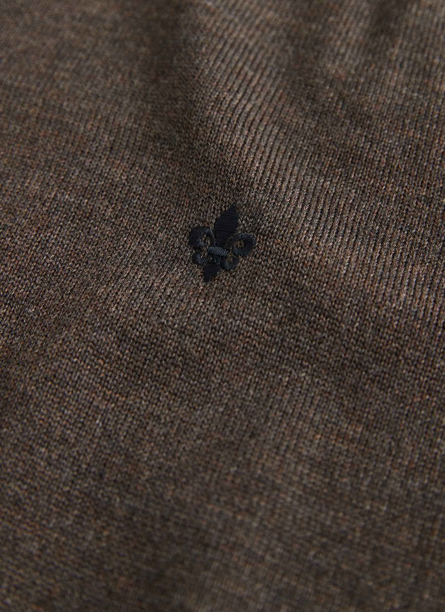 Detalje af broderet logo på Morris merino strik med rund hals i brun