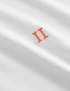 Detalje af orange broderet logo på Les Deux Nørregaard T-shirt i hvid