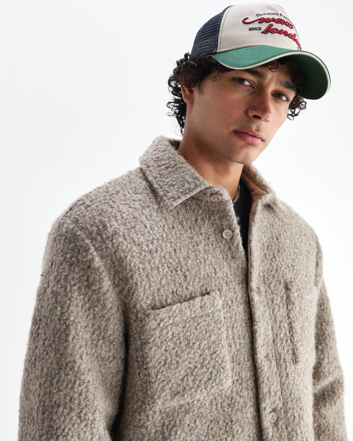 Model med kasket i Wax London Mount vendbar overshirt i bouclé-uld i natur